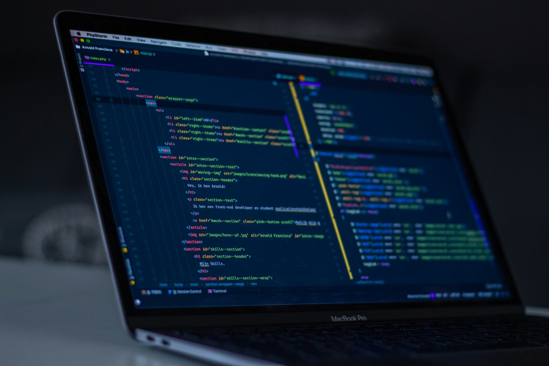 Software development workspace with code on a laptop